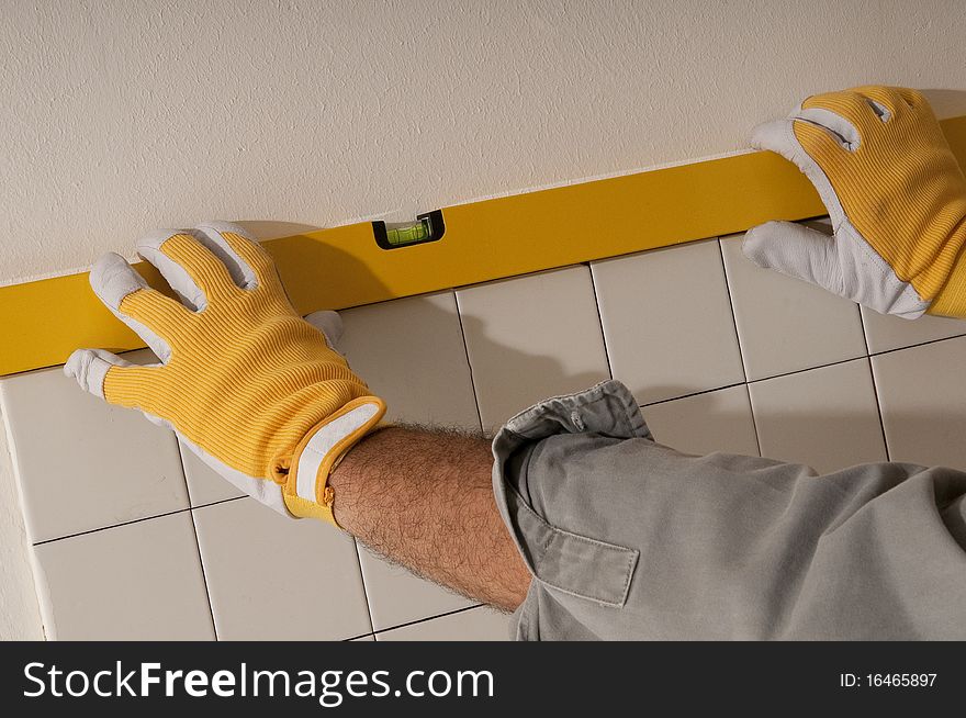 Man using level/ruler with gloves