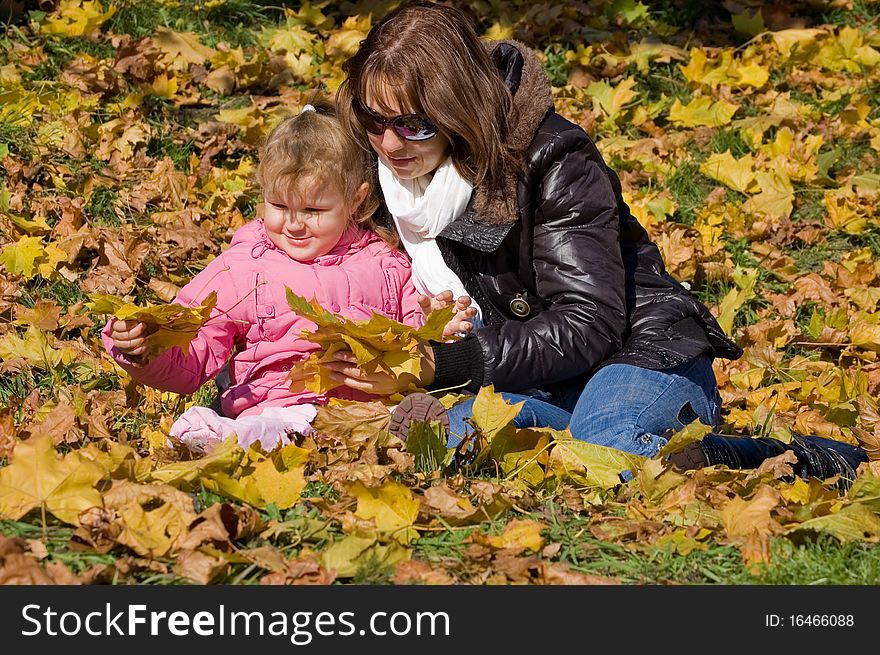 Mama with a daughter in autumn park
