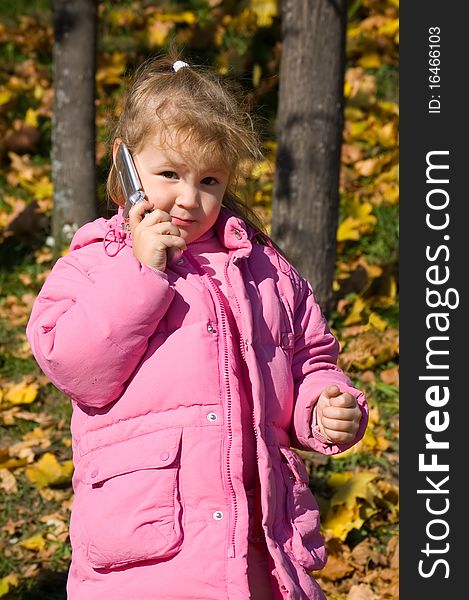 The little girl talks on a cellular telephone
