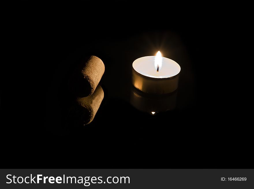 Cork and candle on a black background