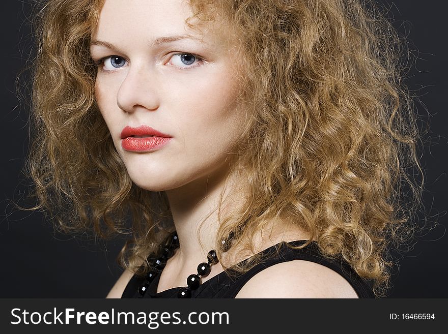Image of beautiful young woman with curly hairs looking at camera