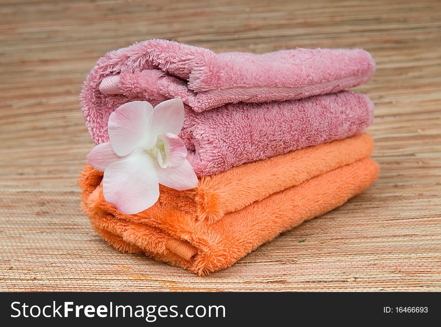 Two rolled towels and flower pink orchid. Two rolled towels and flower pink orchid