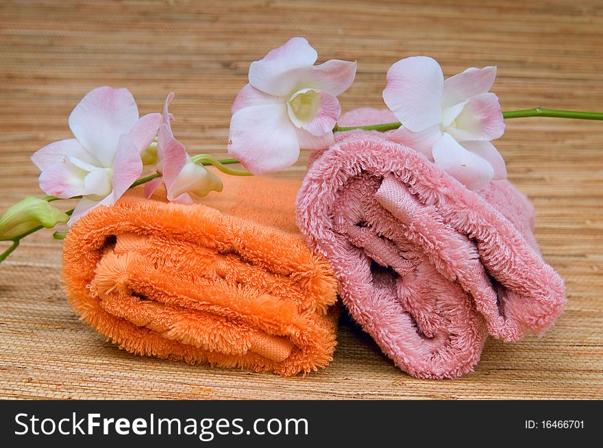 Two rolled towels and flower pink orchid. Two rolled towels and flower pink orchid