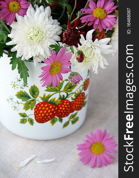 Wild flowers in a vase on a wooden table. Wild flowers in a vase on a wooden table