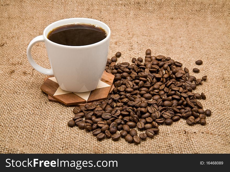 Grains and cup of coffee on a background rough material