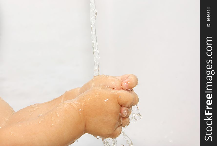 Child washes his hands under running water