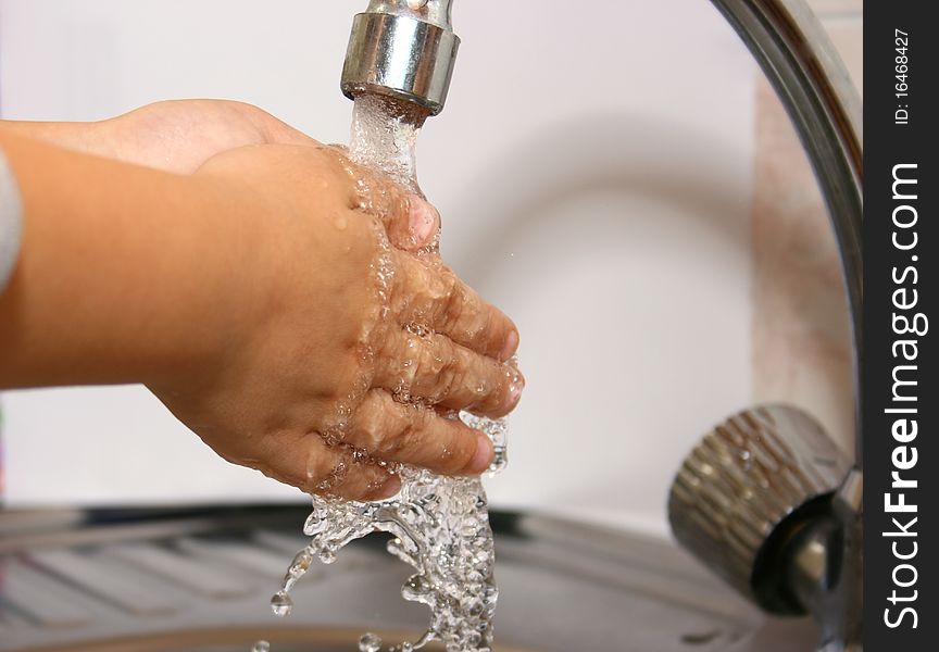 Child washes his hands under the faucet. Child washes his hands under the faucet.