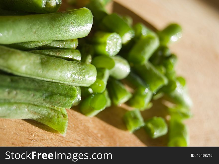 Fresh green beans cut in pieces on wooden desk