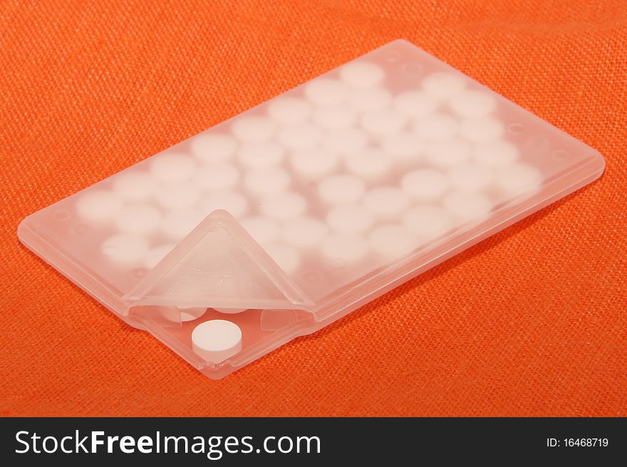 White pills in special plastic container with cover up. White pills in special plastic container with cover up.