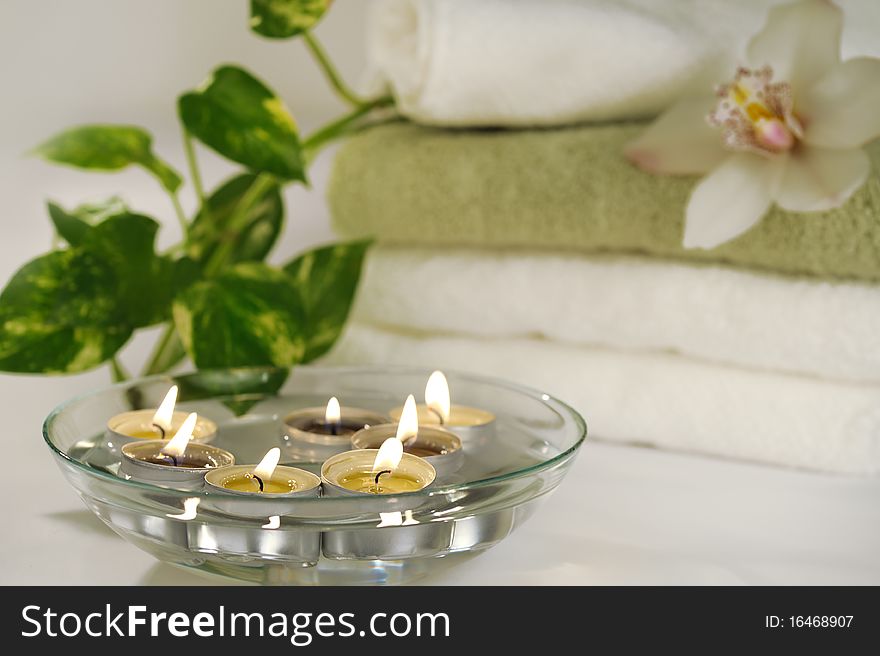 Burn floatind candles with orchid flower on towels. Burn floatind candles with orchid flower on towels