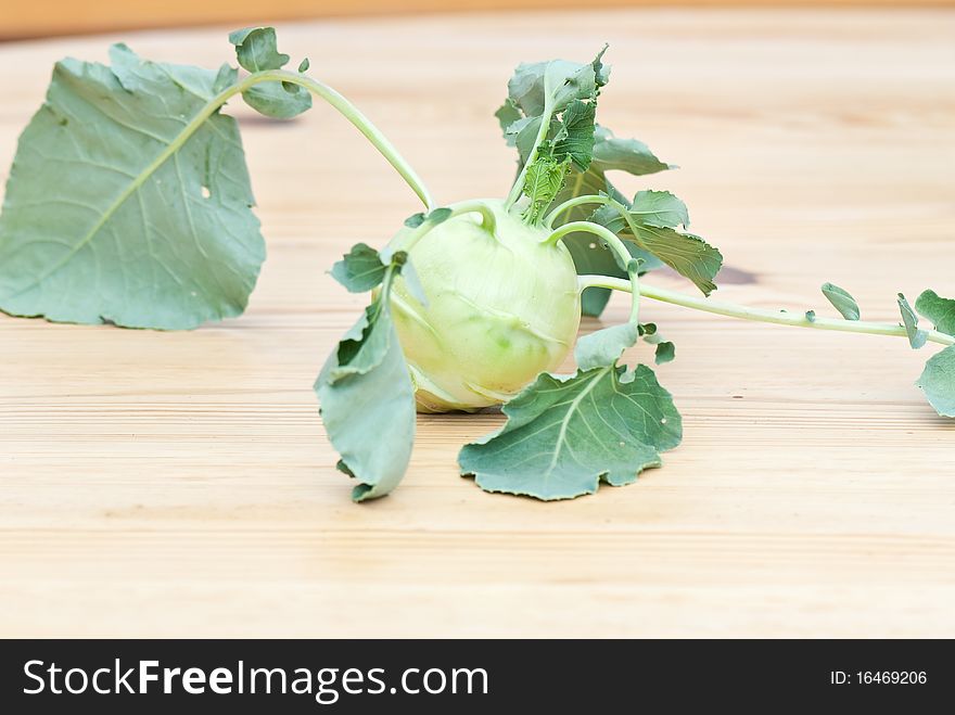 Fresh cabbage kohlrabi with leaves on a wooden table. Fresh cabbage kohlrabi with leaves on a wooden table