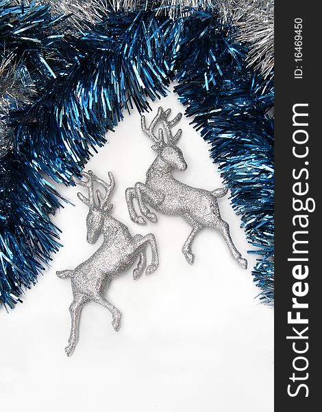 Christmas ornaments - two figures of glittering deer with blue and silver tinsel on white background. Christmas ornaments - two figures of glittering deer with blue and silver tinsel on white background