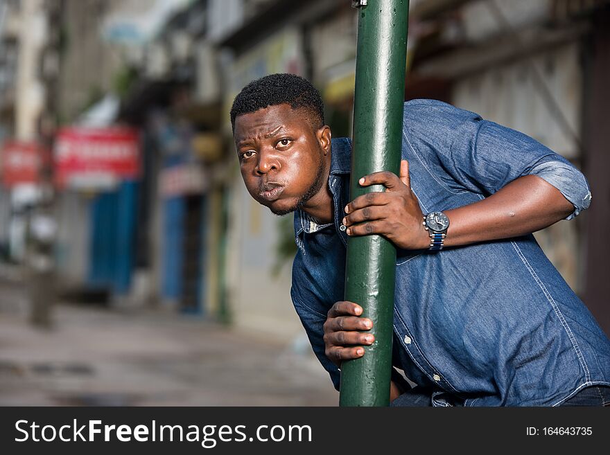 Young african man behind iron bar looking at the camera, surprised. Young african man behind iron bar looking at the camera, surprised