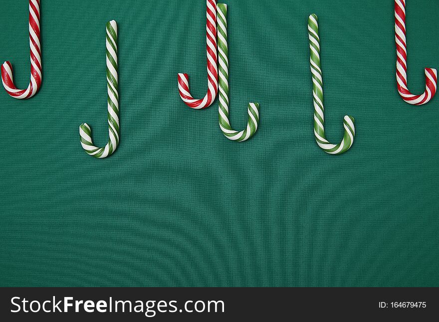 Candy sugar canes on a green background. Christmas background. Concept of Christmas and New Year. Caramel sugar cane concept Copy