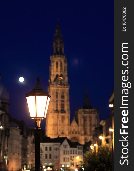 A street light with Cathedral of our Lady at a moon night in the background, Antwerp, Belgium. A street light with Cathedral of our Lady at a moon night in the background, Antwerp, Belgium.