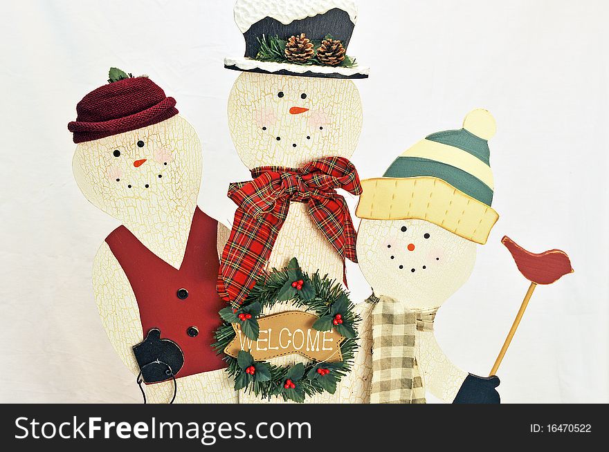 Three wooden snowmen on white background