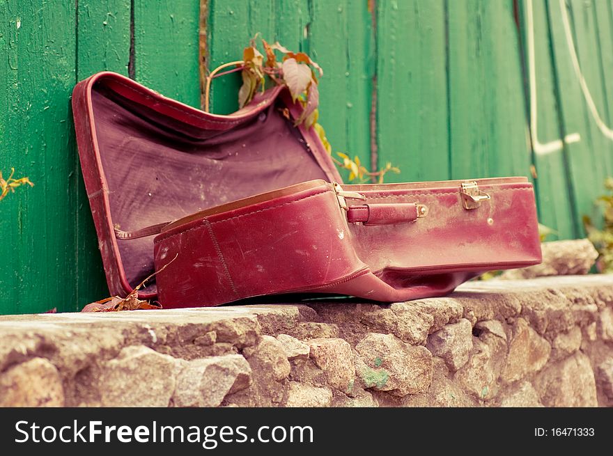 Vintage weathered leather suitcase in the street