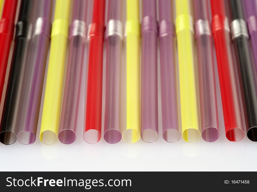 Straws of various colours on a white background