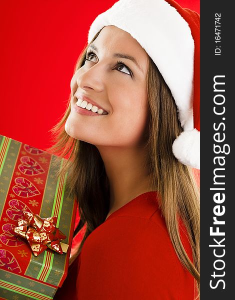 Portrait of a smiling and dreaming Santa Girl with present