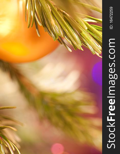 The golden ball hangs on a pine branch on abstract christmas background. The golden ball hangs on a pine branch on abstract christmas background