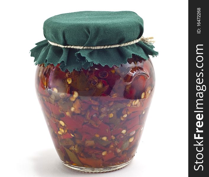 Jar of peppers in oil on a white background