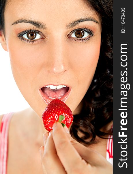 Close-up of young beautiful female eating strawberry, looking at camera. Close-up of young beautiful female eating strawberry, looking at camera