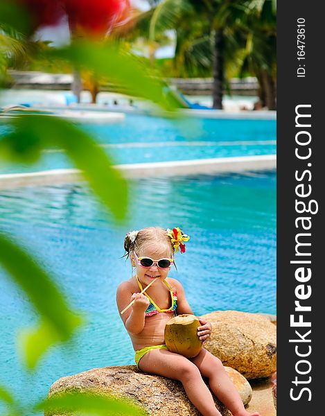 Portrait of cheerful toddler girl with coconut cocktail in exotic beach background. Portrait of cheerful toddler girl with coconut cocktail in exotic beach background