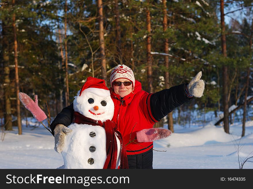 Woman poses with snowman on winter background