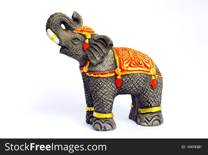 Black elephant casting from plaster and painted with gold dressed stand on the floor and raise his nose on the top.