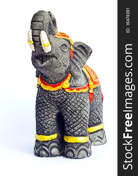 Black elephant casting from plaster and painted with gold dressed stand on the floor and raise his nose on the top.
