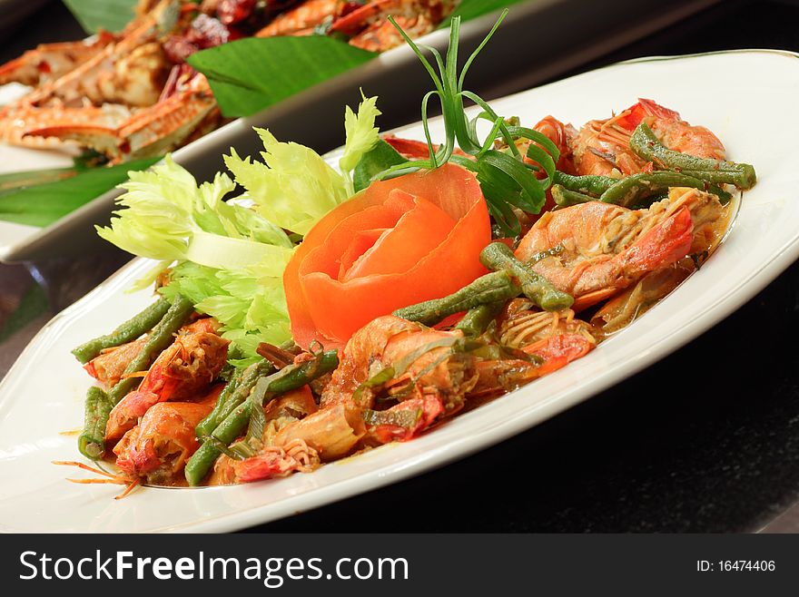 A dish of spicy chili prawn served with garnishing and tomato