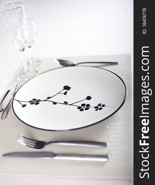 A dinner plate, knife, spoon and fork