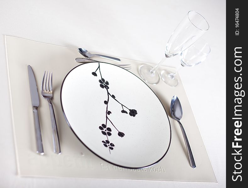 A dinner plate, knife, spoon and fork