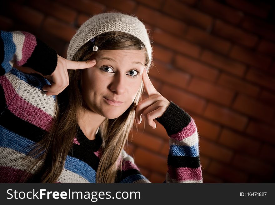 Cute girl making funny smile on the brick wall. Cute girl making funny smile on the brick wall