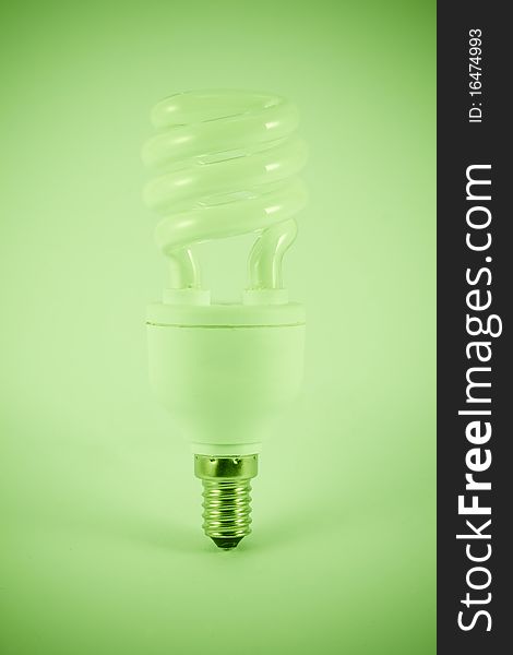 Energy saving light bulb whit a green light. Isolated on white background.