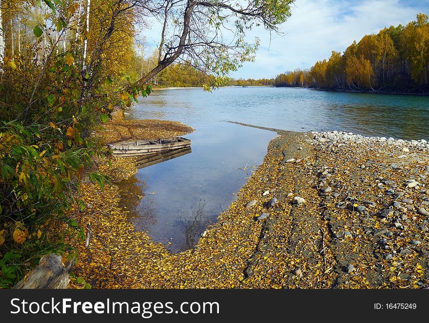 Autumn mountain river scenic with wooden boat. Autumn mountain river scenic with wooden boat