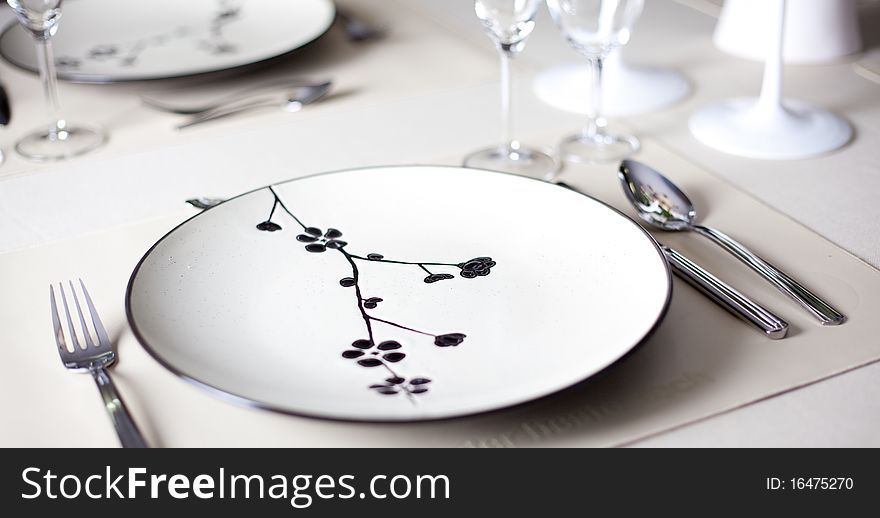 A dinner plate, knife, spoon and fork