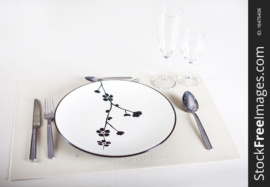 A dinner plate, knife, spoon and fork