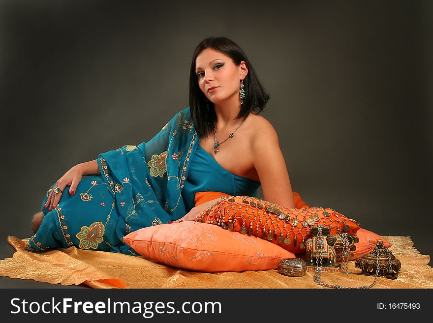 Beautiful indian woman laying in ethnic interior. Beautiful indian woman laying in ethnic interior.