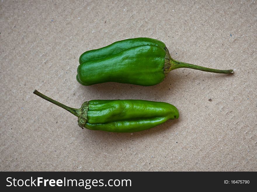 Two Hot Jalapeño peppers on a carton background. Two Hot Jalapeño peppers on a carton background