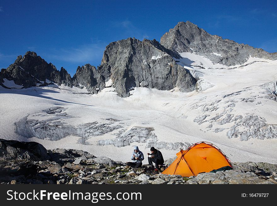 Couple of mountaneers having a breakfast in Caucasus mountains. Couple of mountaneers having a breakfast in Caucasus mountains