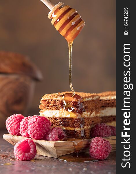 Layered honey cake with cream and red raspberries