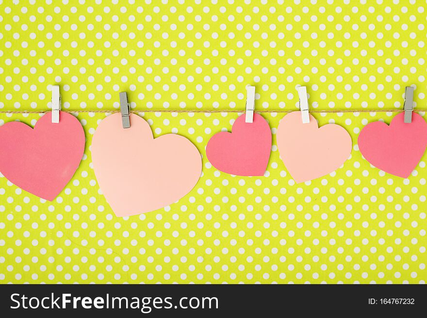 Pink paper hearts hanging at a rope for Valentine`s Day, Mother`s Day or Women`s Day decoration with copy space