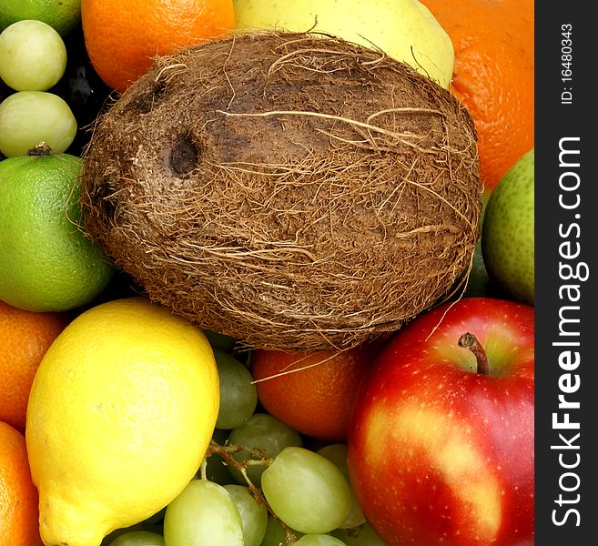 A closeup image of fresh and tasty apples, lemons, grapes and a coconut. A closeup image of fresh and tasty apples, lemons, grapes and a coconut.