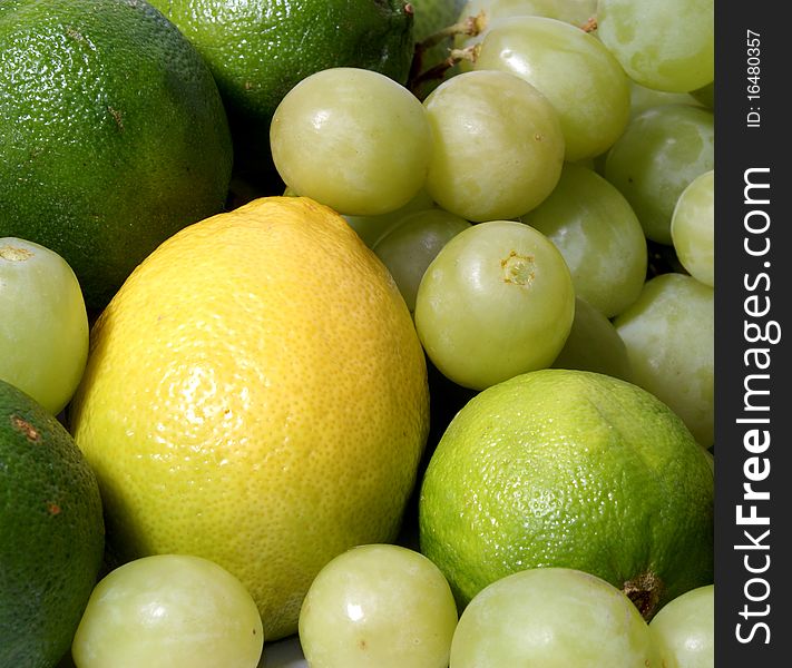 A set of different healthy and tasty fruits. Composition consists of grapes, limes and a lemon.