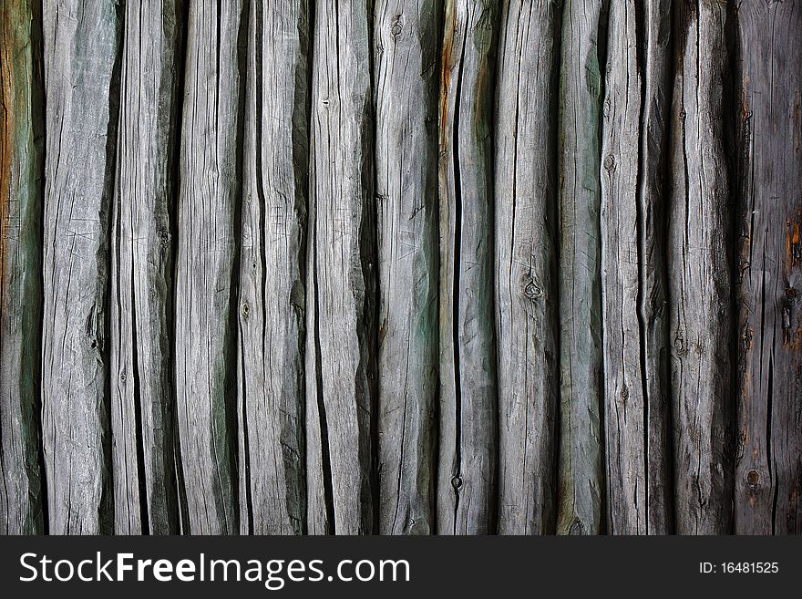 Fence from logs. Backgrounds. Old wooden fence.