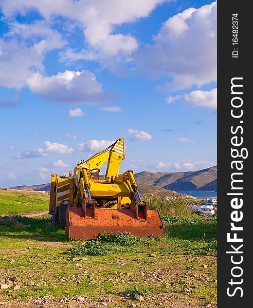 Yellow bulldozer on the grass in the countryside