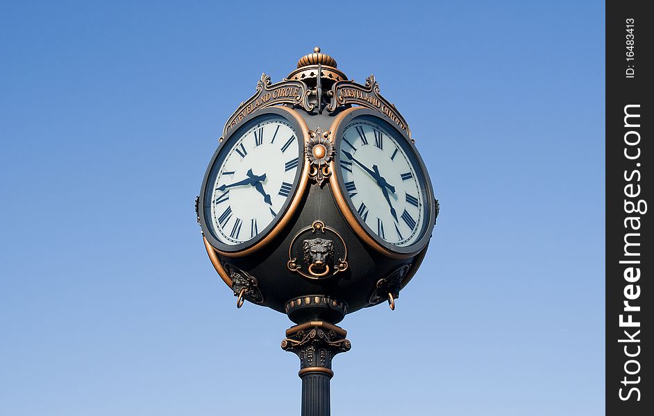 Outdoor round four faced clock on blue with clipping path. Outdoor round four faced clock on blue with clipping path