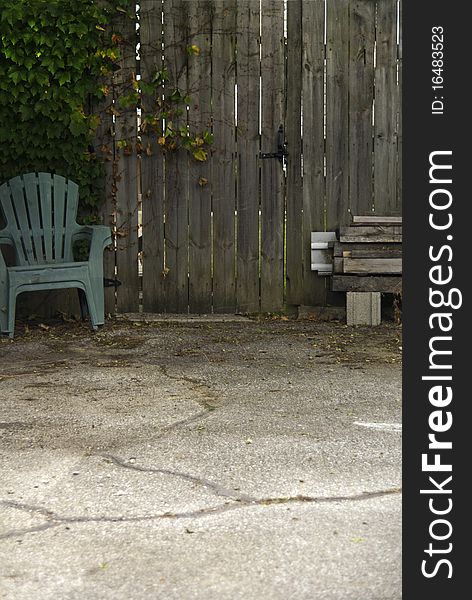 A view of a patio garden chairs, ivy vines and a privacy fence. A view of a patio garden chairs, ivy vines and a privacy fence.