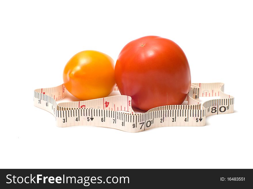Measuring tape around a red and yellow tomatoes.